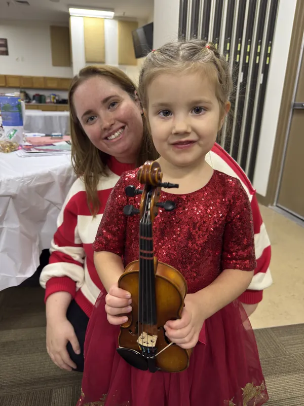 Emily Gasper with a young Twinkle student holding her first violin.